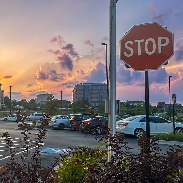A stop sign silhouetted against a sunset